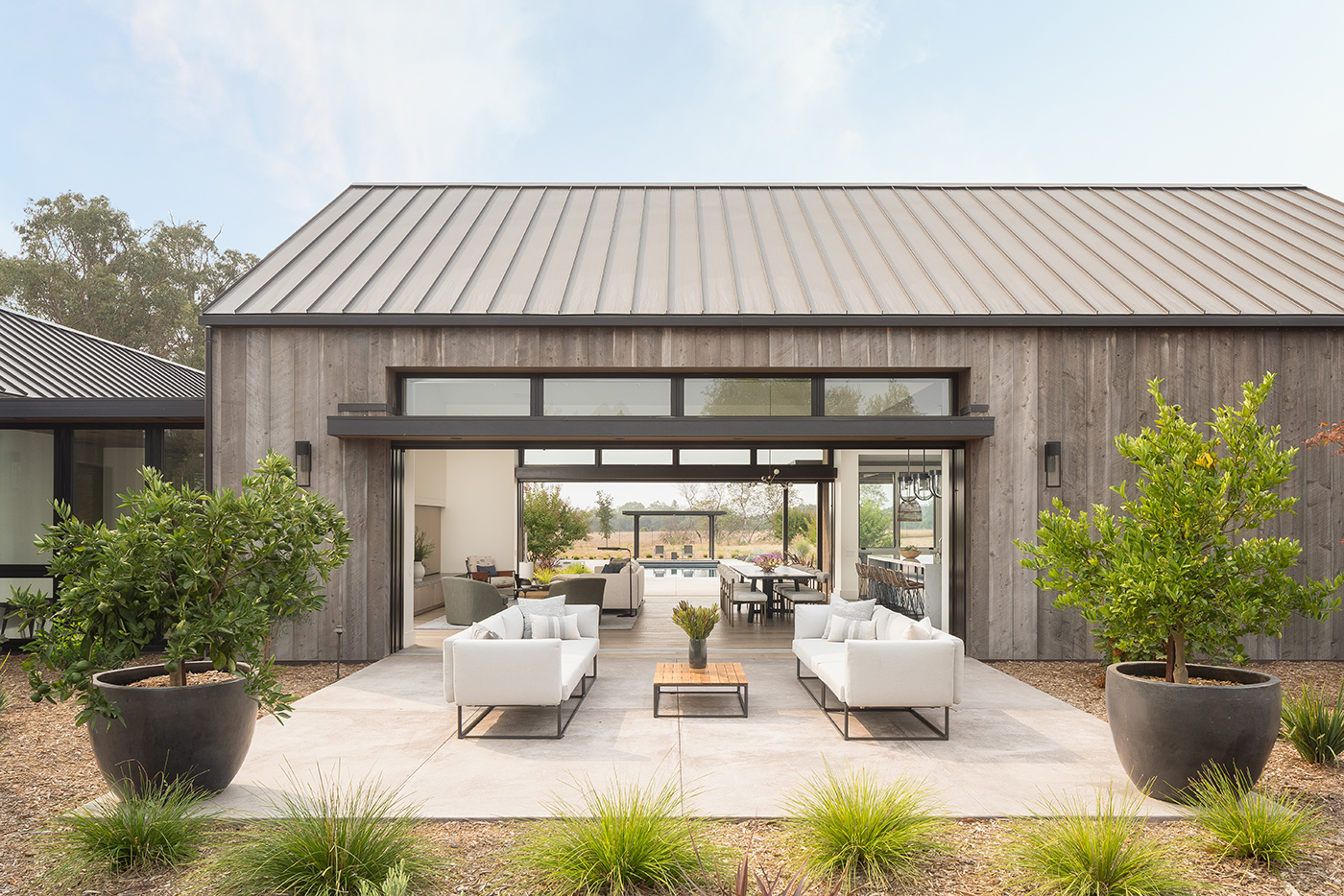 Modern barn-form home with standing-seam roof and weathered siding
