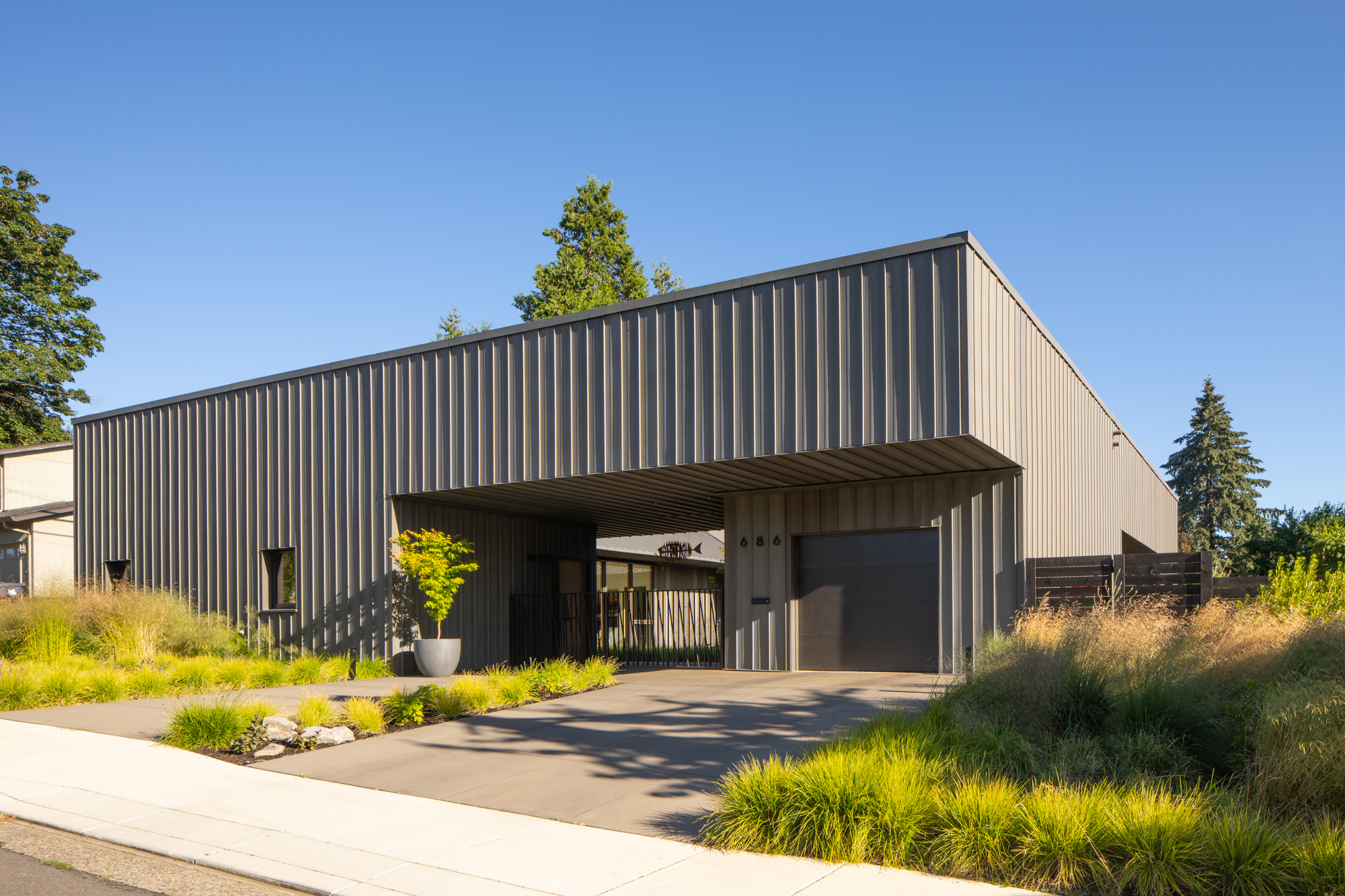Pacific Northwest modern home with metal siding among Douglas firs