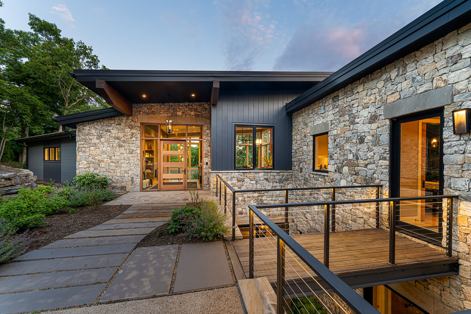 Stone and dark board-and-batten entry at dusk